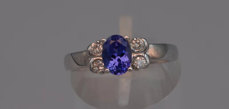 Ladies night shimmer rings -14K white gold ring with one center oval Tanzanite and four side diamonds